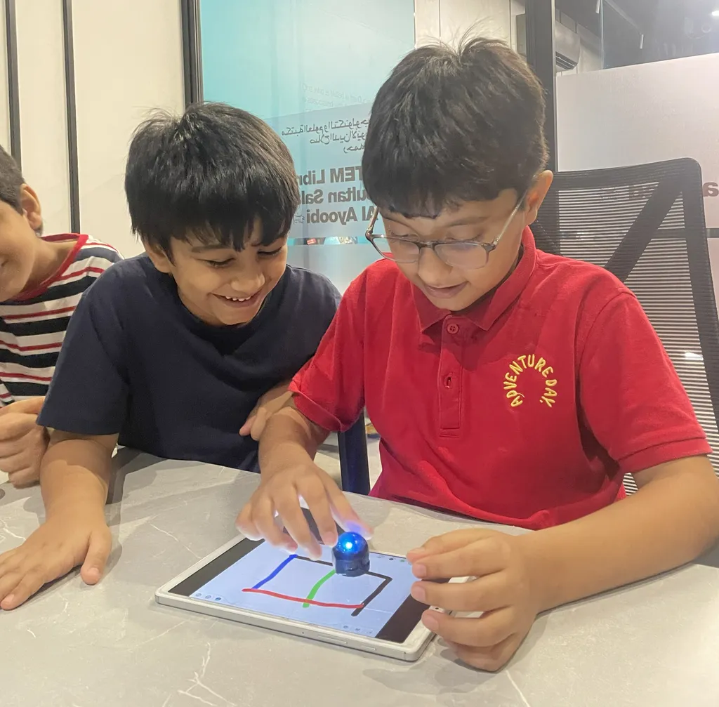 Students programming an Ozobot robot on a tablet